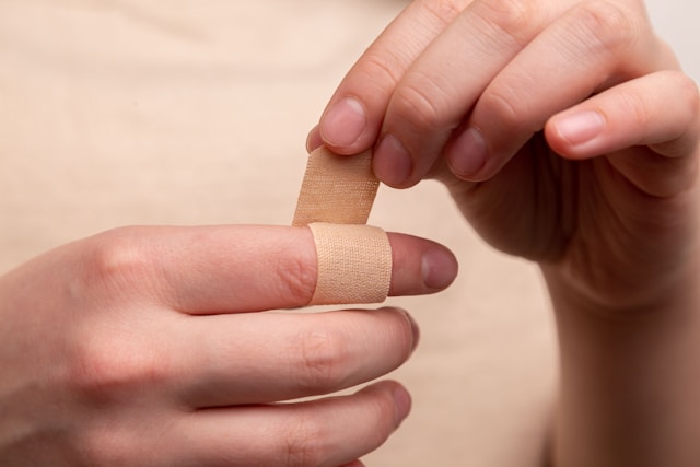 index finger with bandaid being applied