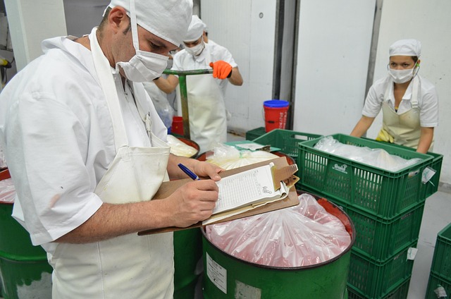 Staff in a food factory, one using a clipboard